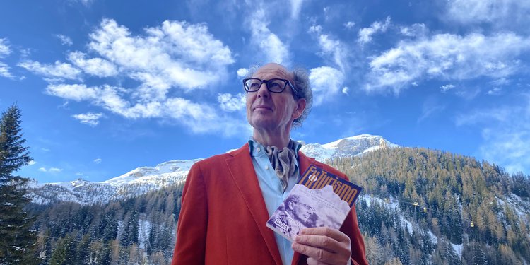 Lo scrittore Michil Costa fotografato in montagna con il suo libro FuTurismo