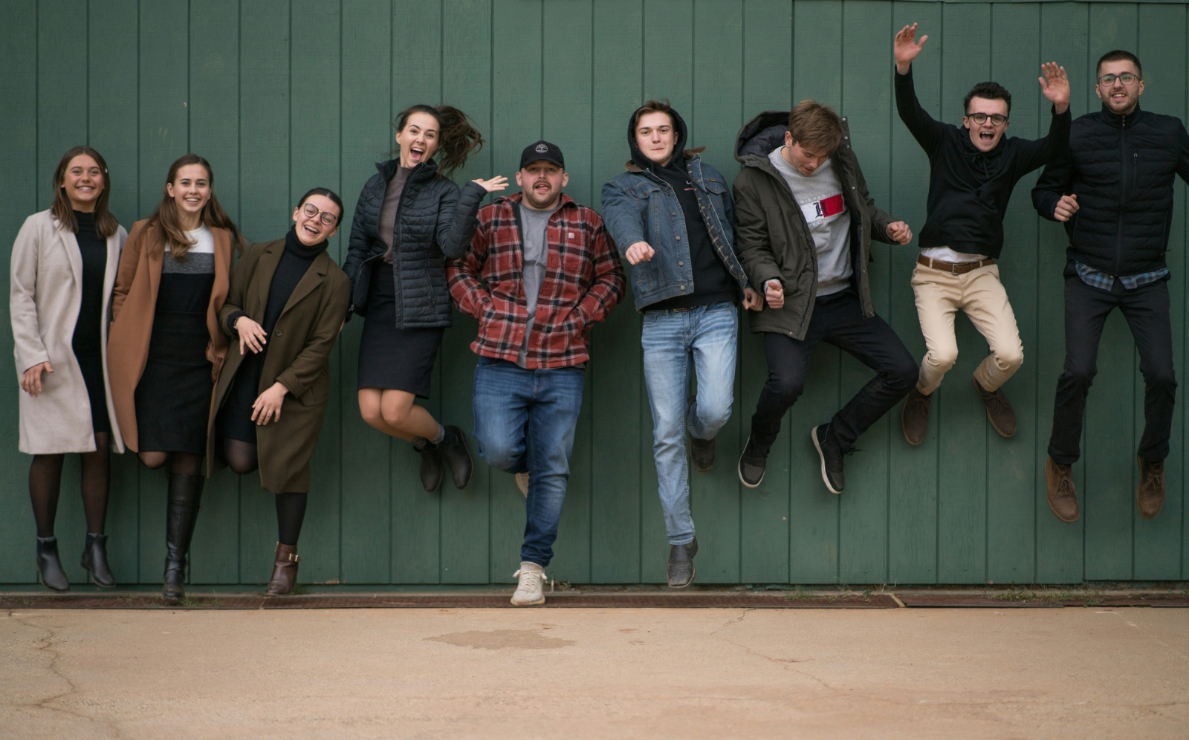 Fotografia con ragazze e ragazzi in piedi che sorridono