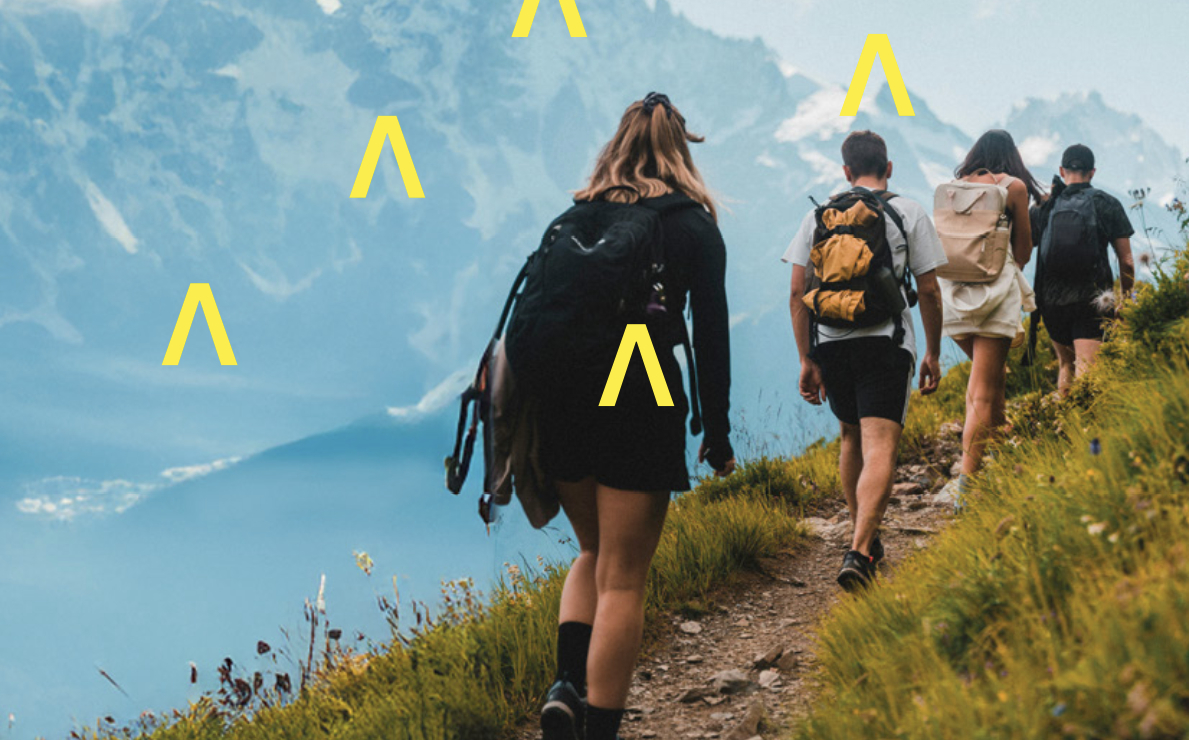 Immagine raffigurante quattro persone riprese di schiena durante un trekking in alta montagna