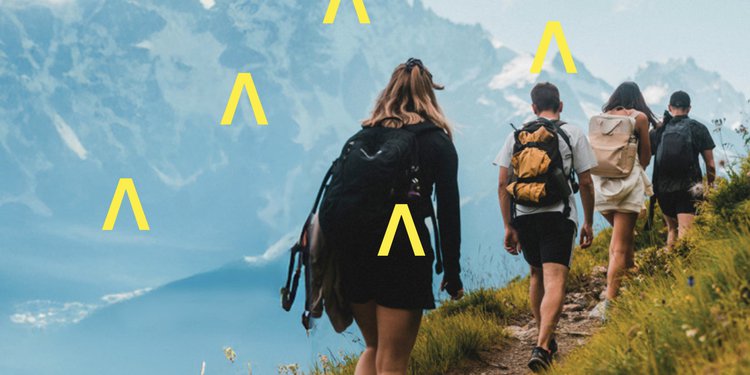 Immagine raffigurante quattro persone riprese di schiena durante un trekking in alta montagna