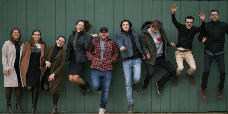 Fotografia con ragazze e ragazzi in piedi che sorridono
