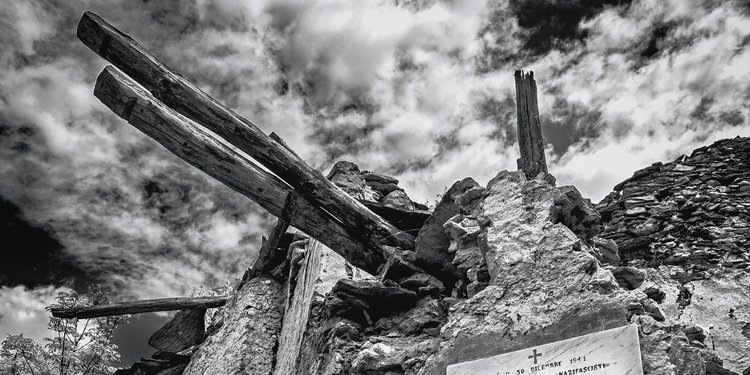 Fotografia di una targa commemorativa, posta sul muro di un'abitazione montana abbandonata, in ricordo dei partigiani Spirito Rovera e Francesco Cusato